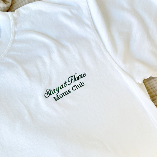 white comfort colors tshirt with embroidered stay at home moms club design small on the left chest in hunter green thread