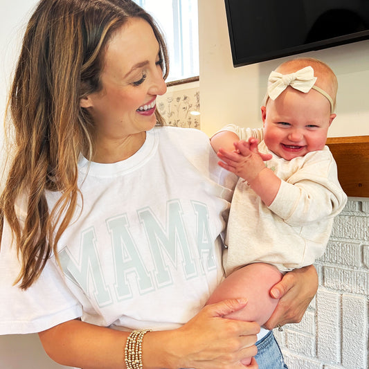 OMAN HOLDING BABY AND WEARING A WHITE COMFORT COLORS TEE WITH MAMA DTF PRINT