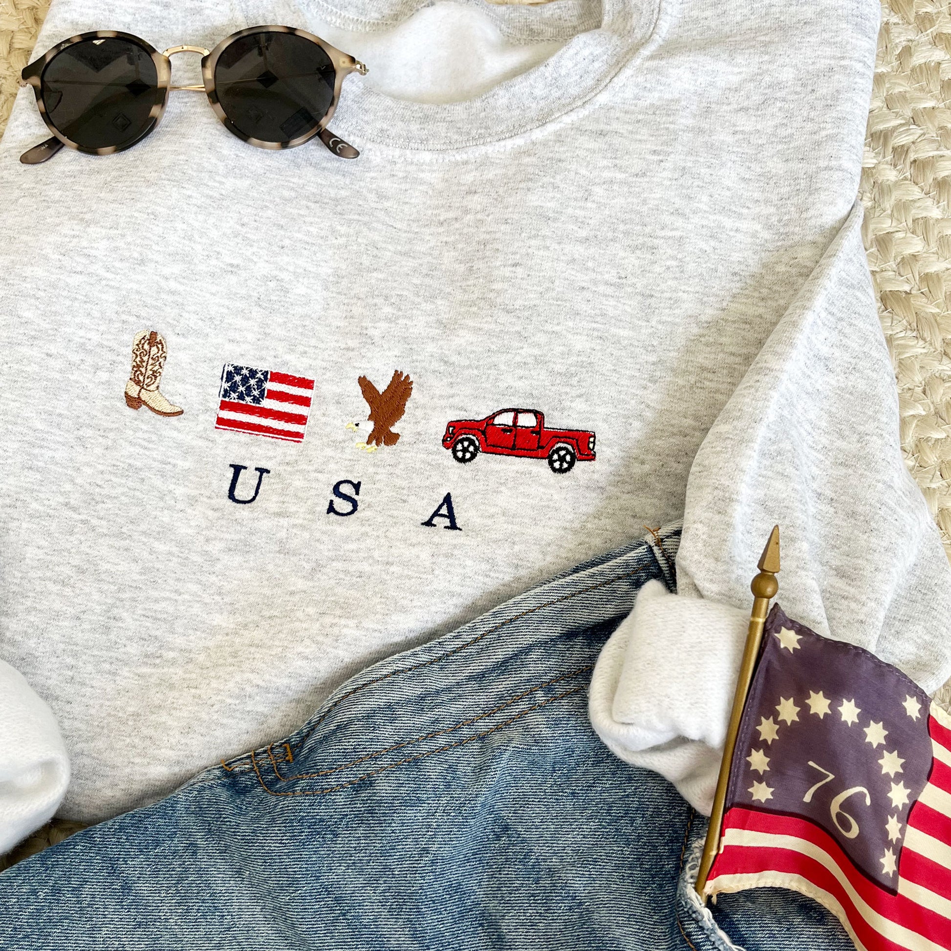 ASH GREY CREWNECK SWEATSHIRT WITH EMBROIDERED COWBOY BOOT, AMERICAN FLAG, EAGLE, TRUCK AND USA EMBROIDERED DESIGN ACROSS THE CENTER CHEST