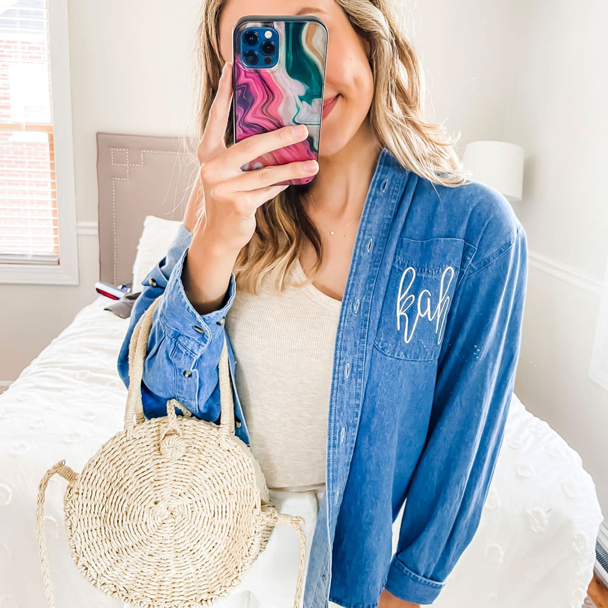 woman styling a denim button up shirt with kah embroidred monogram on the let chest pocket in white thread