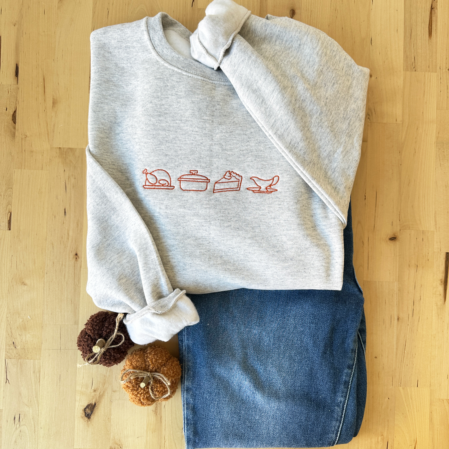 crewneck sweatshirt featuring an outlined turkey, casserole dish, pumpkin pie, and gravy boat outlined embroidered design