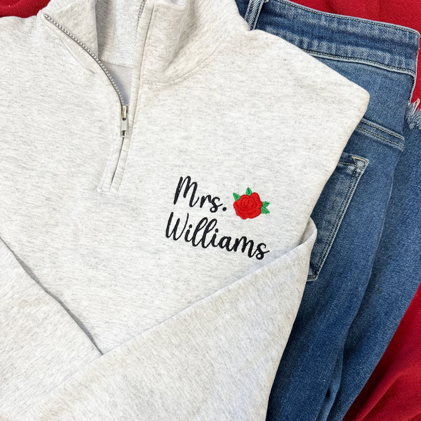 ash gray quarter zip with a custom name and mini rose embroidered design on the left chest