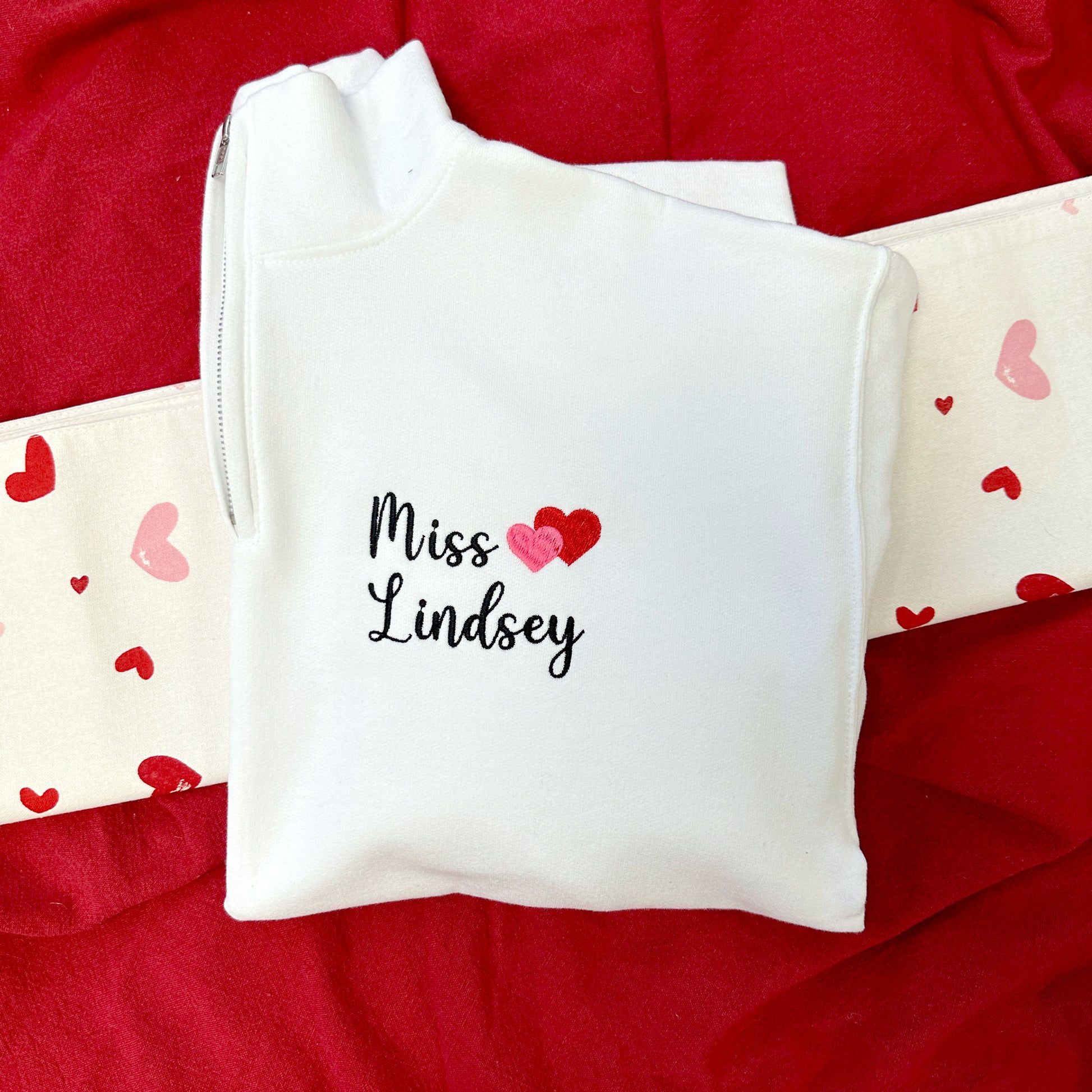 white quarter zip for a teacher with name and mini heart embroidered design on the left chest