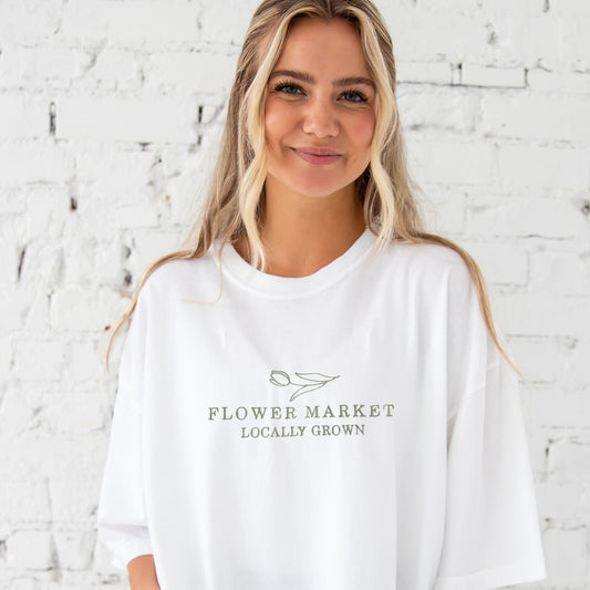 girl wearing white tee with  flower market embroidered design