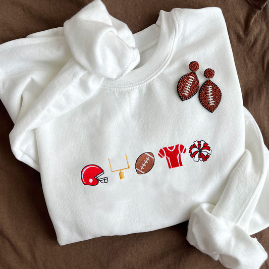 flat lay of a white crewneck sweatshirt with embroidered football icons across the chest with red accent color