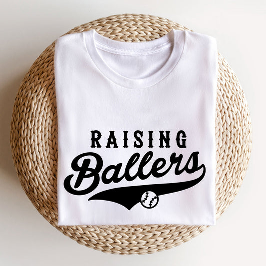 Image of a white t-shirt featuring a 'raising ballers' t-shirt in a sporty varsity mixed font