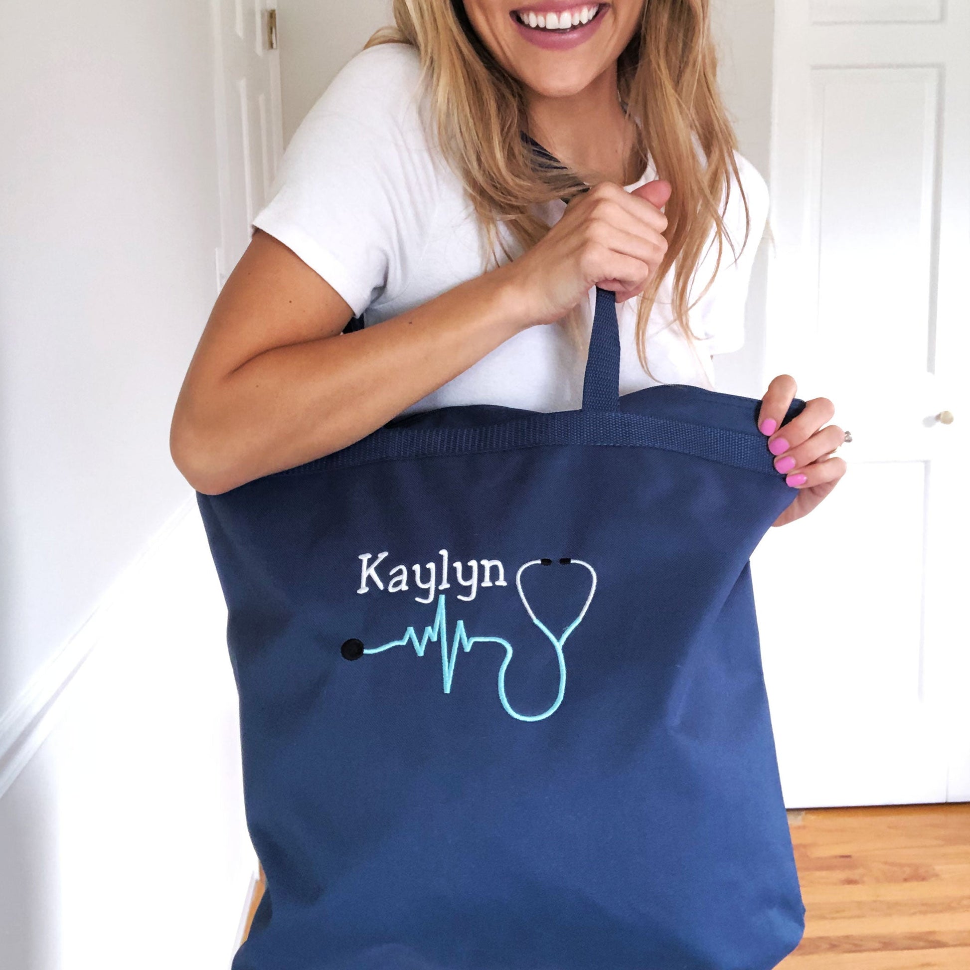 woman holding navy bag with name and stethoscope embroidered