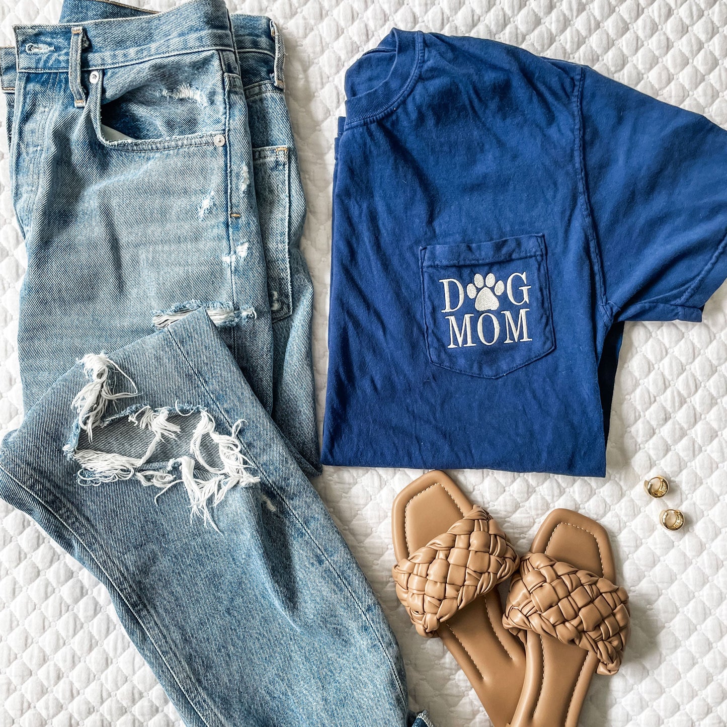 flatlay of outfit featuring distressed jeans, sandals, and navy blue comfort colors tee with dog mom embroidered on the pocket