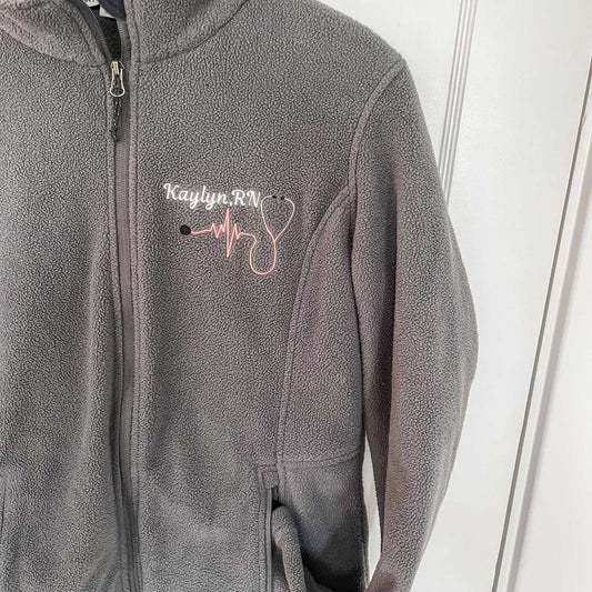 textured fleece full zip jacket with collar and zippered pockets featuring a customized nurse stethoscope embroidery design on the left chest