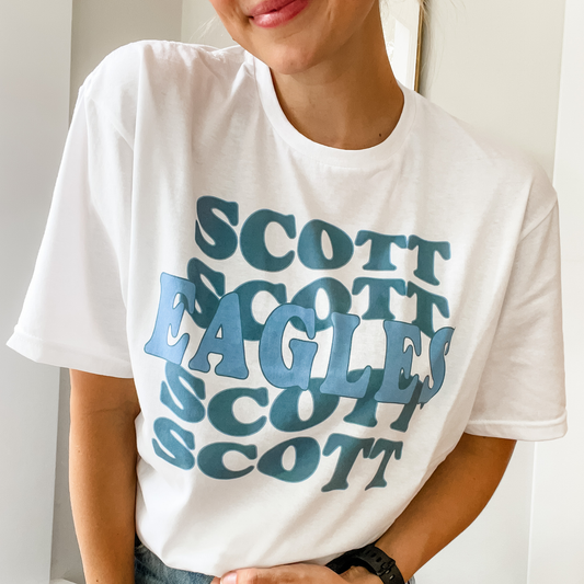 girl wearing a white t-shirt featuring a custom school and mascot printed design in blue ink and a retro wave font