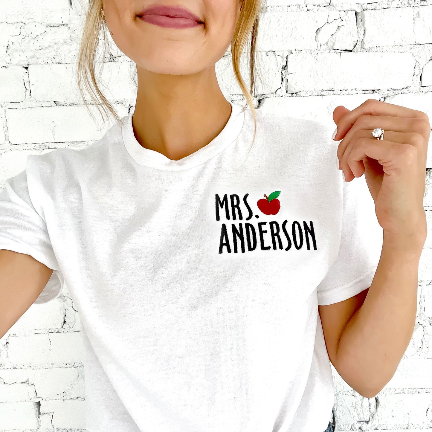 woman smiling with teachers names and mini apple embroidered on left