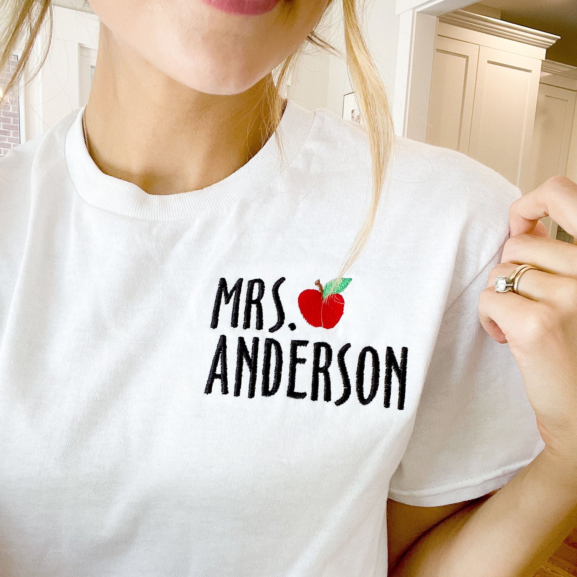 close up of educators name and mini apple design on white tee