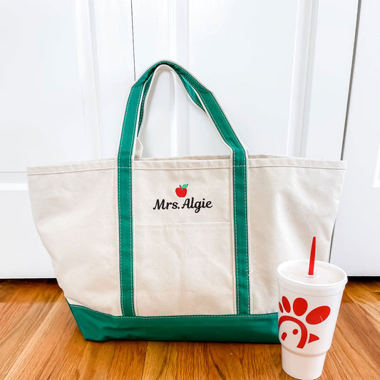 green tote sitting on ground with drink sitting next to it