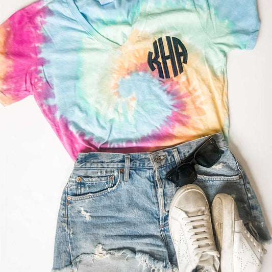 outfit flatlay of monogrammed v-neck tee with a traditional round embroidered monogram in black thread on the left chest.