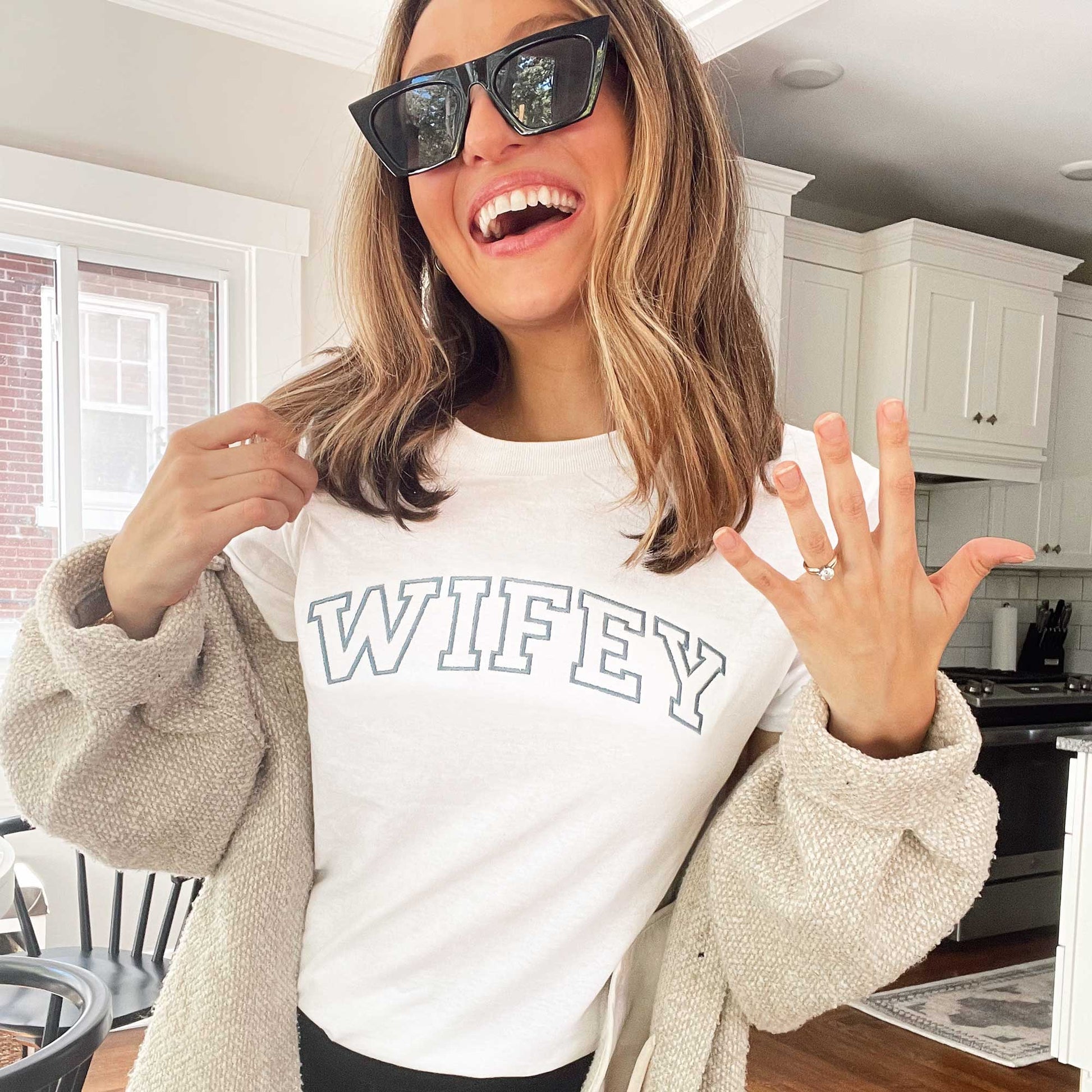 woman showing off her engagement ring wearing a custom wifey tee