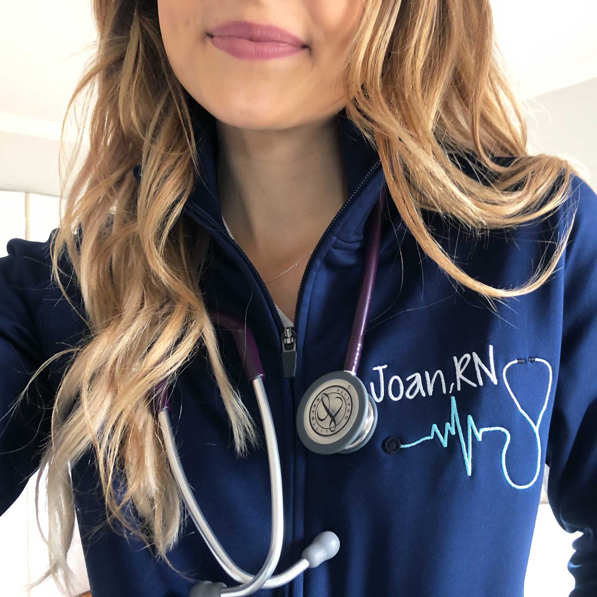 nurse wearing a custom embroidered navy blue polyester full zip jacket 