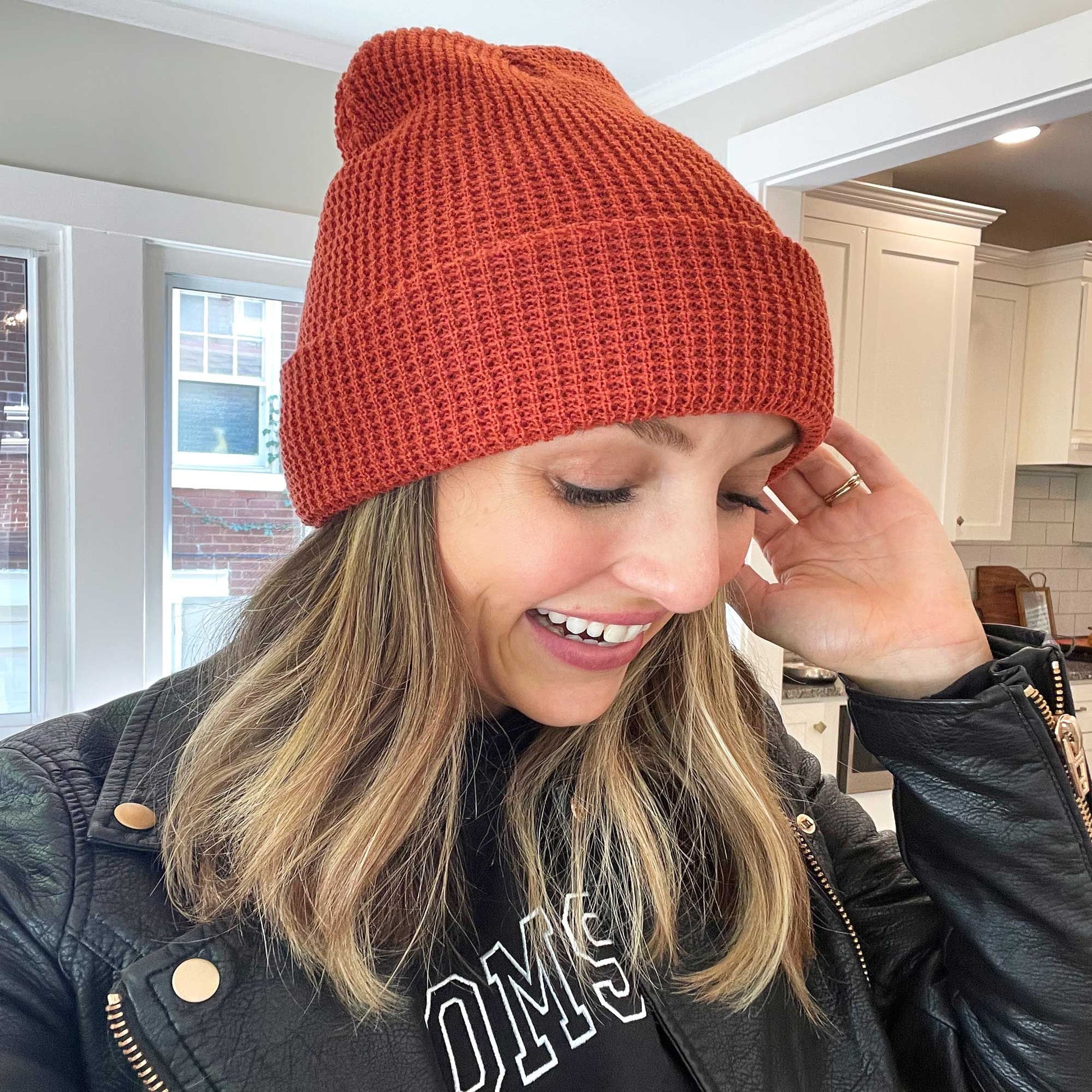 girl wearing a cuffed waffle knit beanie in a rusty orange color