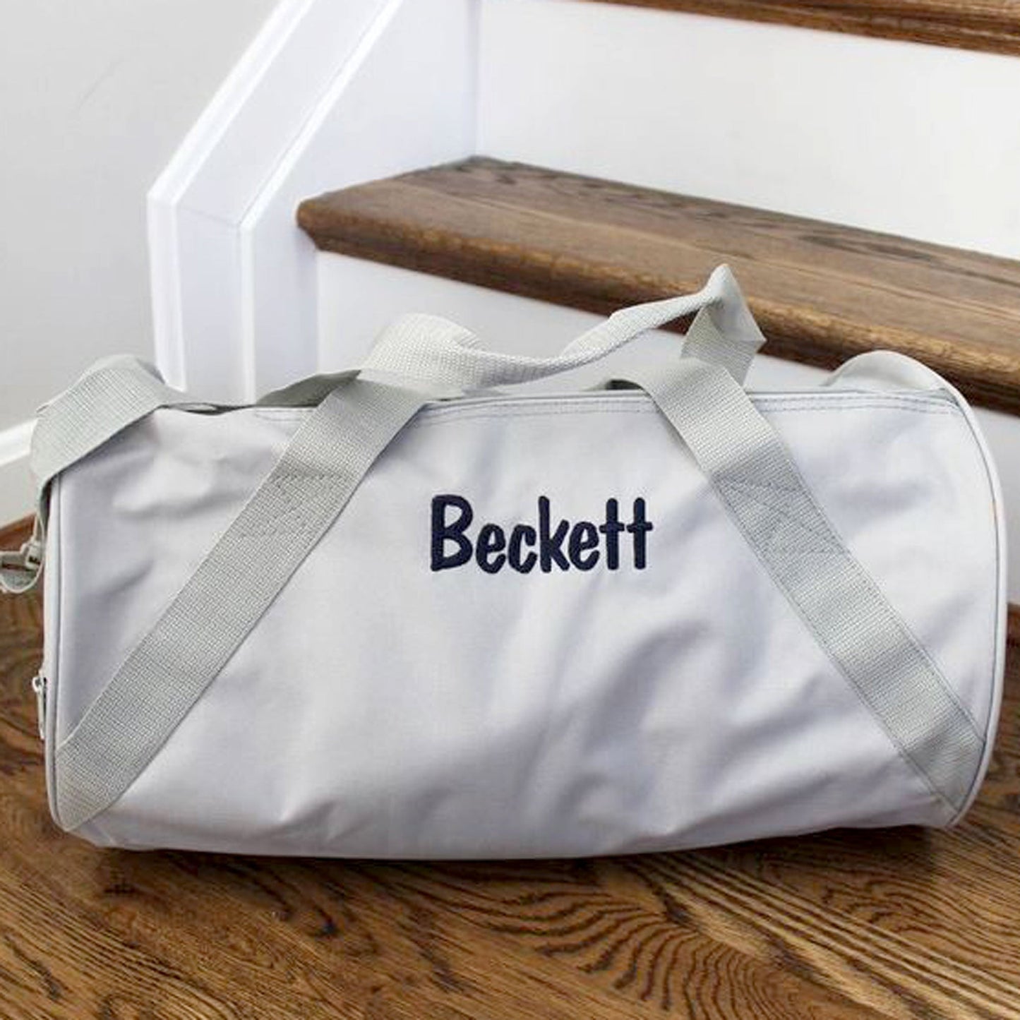 gray duffle with name Beckett sitting on steps