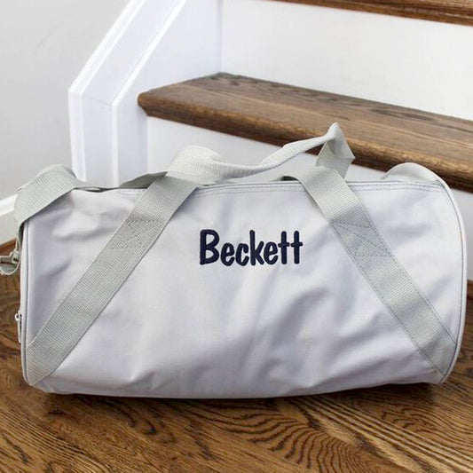 gray duffle with name Beckett sitting on steps