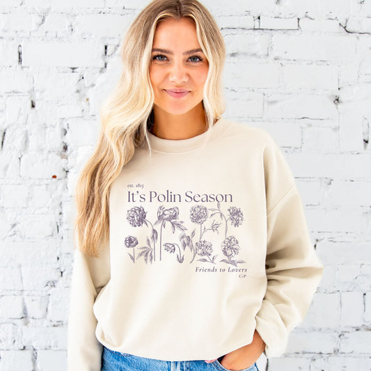 woman wearing a sand pullover sweatshirt with a bridgerton inspired polin season printed design