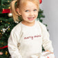 toddler wearing a heather oatmeal crewneck sweatshirt with embroidered merry mini design in red thread across the chest