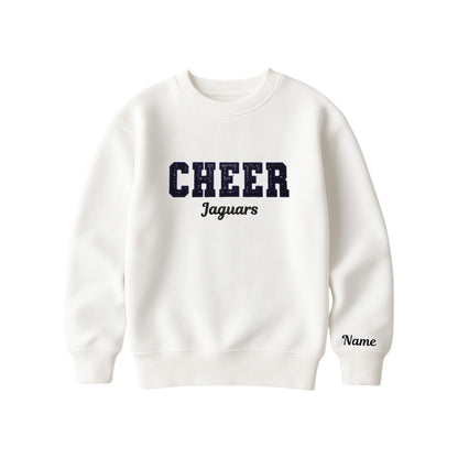 bleached linen boxy crewneck sweatshirt with black glitter applique embroidery reading cheer with jaguars embroidered in a script font underneath, and an optional name embroidery in a script font on the left sleeve 