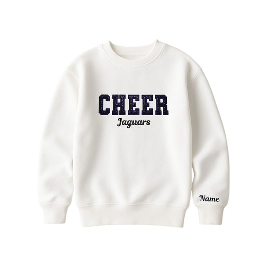 bleached linen boxy crewneck sweatshirt with black glitter applique embroidery reading cheer with jaguars embroidered in a script font underneath, and an optional name embroidery in a script font on the left sleeve 
