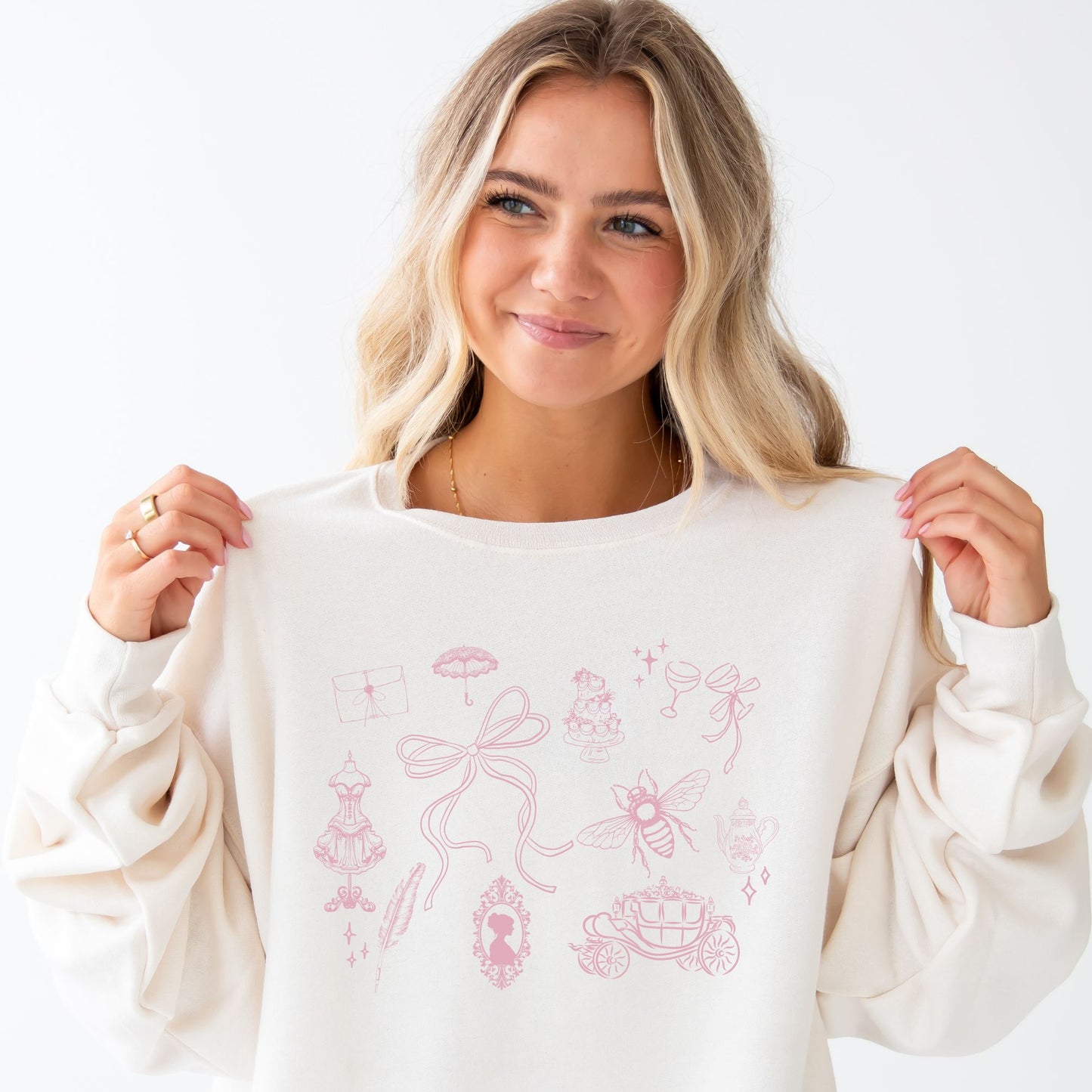 girl wearing an oversized sweet cream sweatshirt featuring a cute bridgerton inspired coquette icon crew