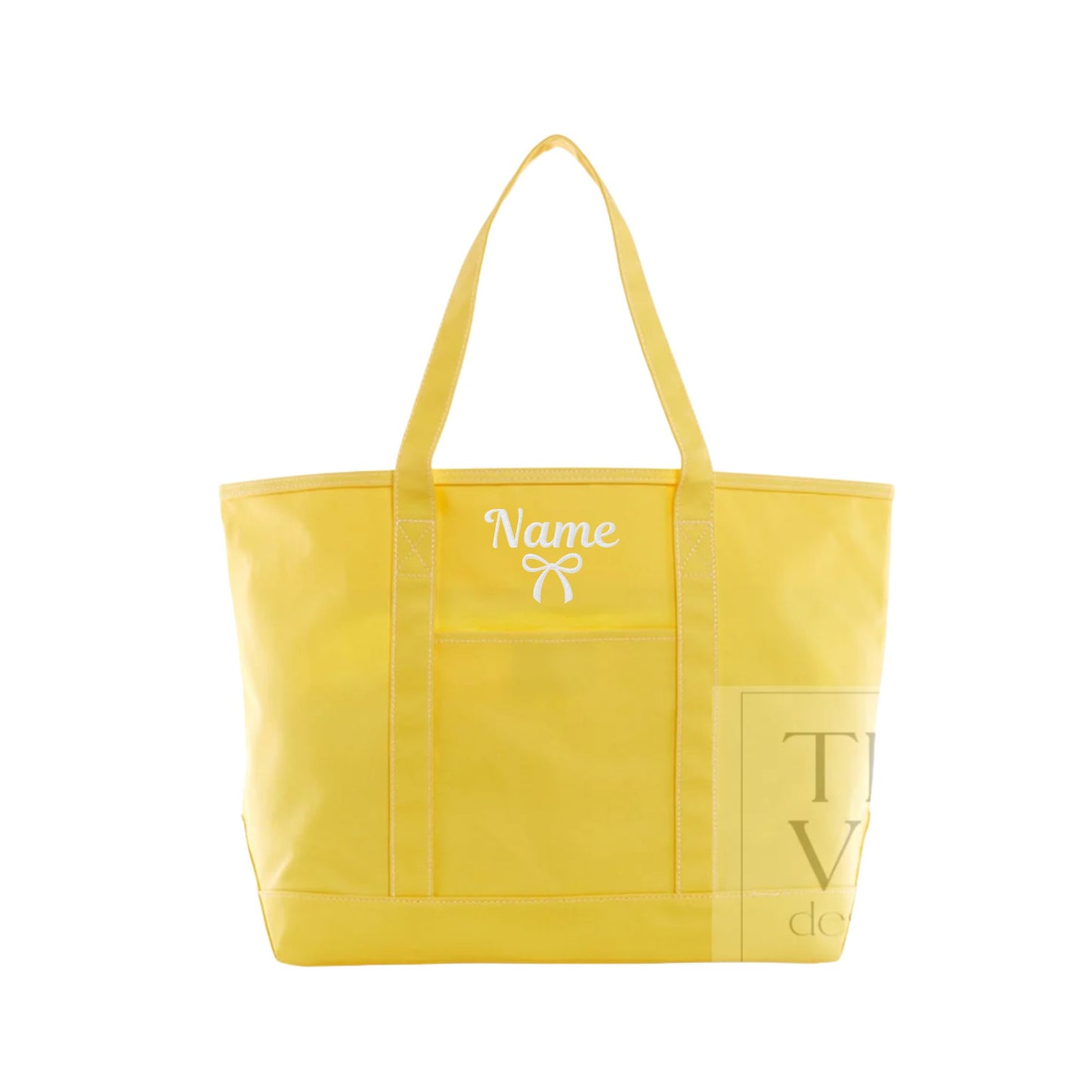 A bright yellow canvas tote bag with two shoulder straps, featuring a white embroidered 'Name' text and bow design on the front pocket, and a gold-toned printed logo on the lower right front panel.
