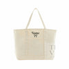 An off-white canvas tote bag with double shoulder straps, featuring a black embroidered 'Name' and bow on the front pocket