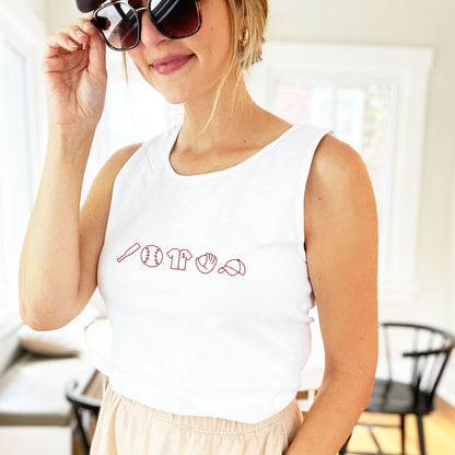 woman wearing shorts and a white comfort colors tank top with a custom baseball icons embroidered design across the chest in red thread