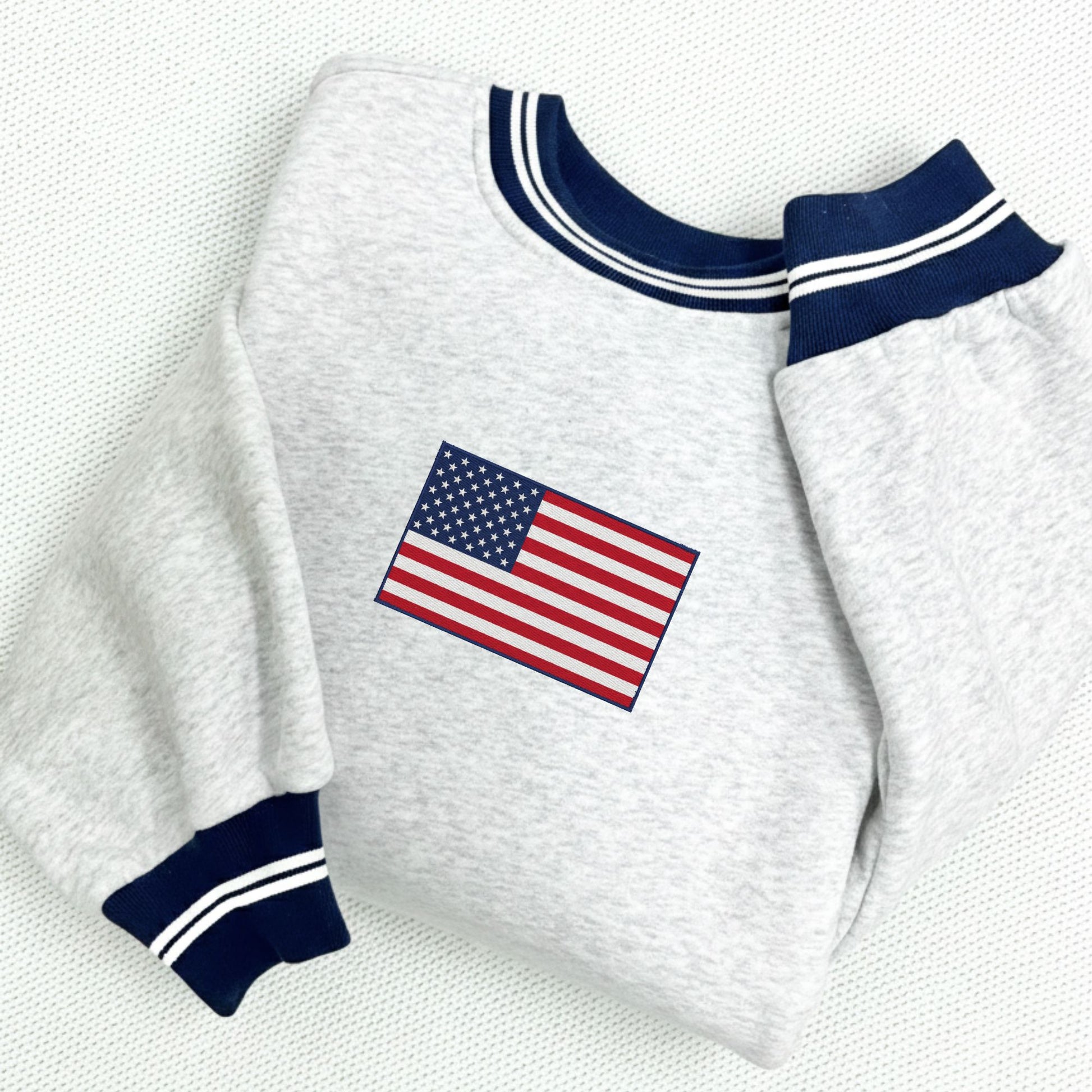 White sweatshirt with American flag embroidery on a white background