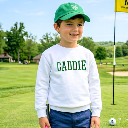 Child wearing a white 3d embroidered 'CADDIE' sweatshirt on a golf course