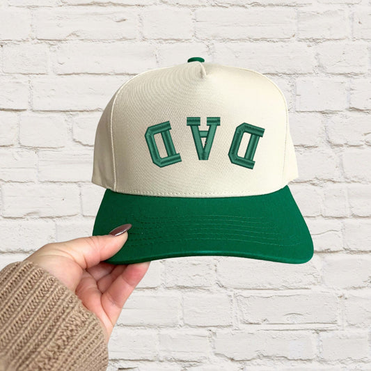 green two-tone canvas trucker hat with custom upside down curved athletic font DAD embroidered design in green thread.