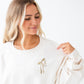 girl wearing a sweet cream crewneck sweatshirt with custom ribbon bow and stacked initials embroidered on the left chest with camel thread