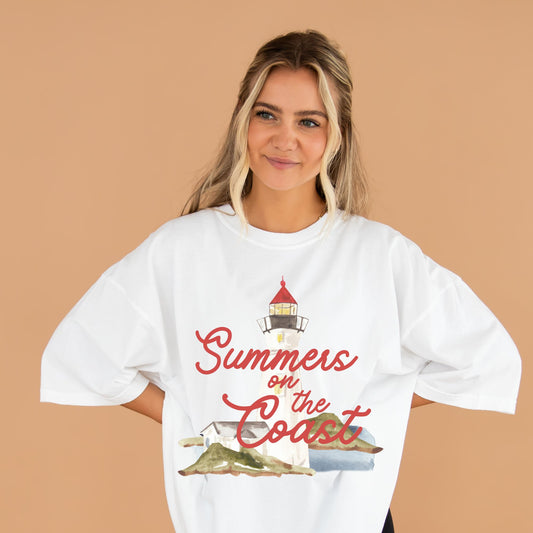 Woman wearing a white t-shirt with 'Summers on the Coast' lighthouse design on a beige background