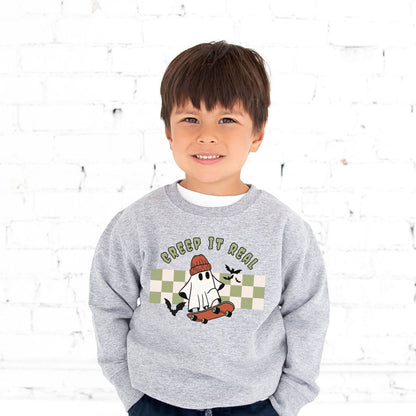 little boy wearing a heather grey crewneck sweatshirt with cute skateboarding ghost and checkered creep it real print