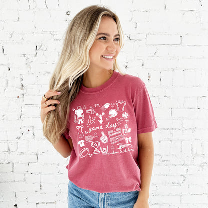 Woman wearing a red t-shirt with white football doodled icons and game day text 