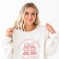 woman wearing a sweet cream crewneck sweatshirt with a romance reader book club pink bow printed design