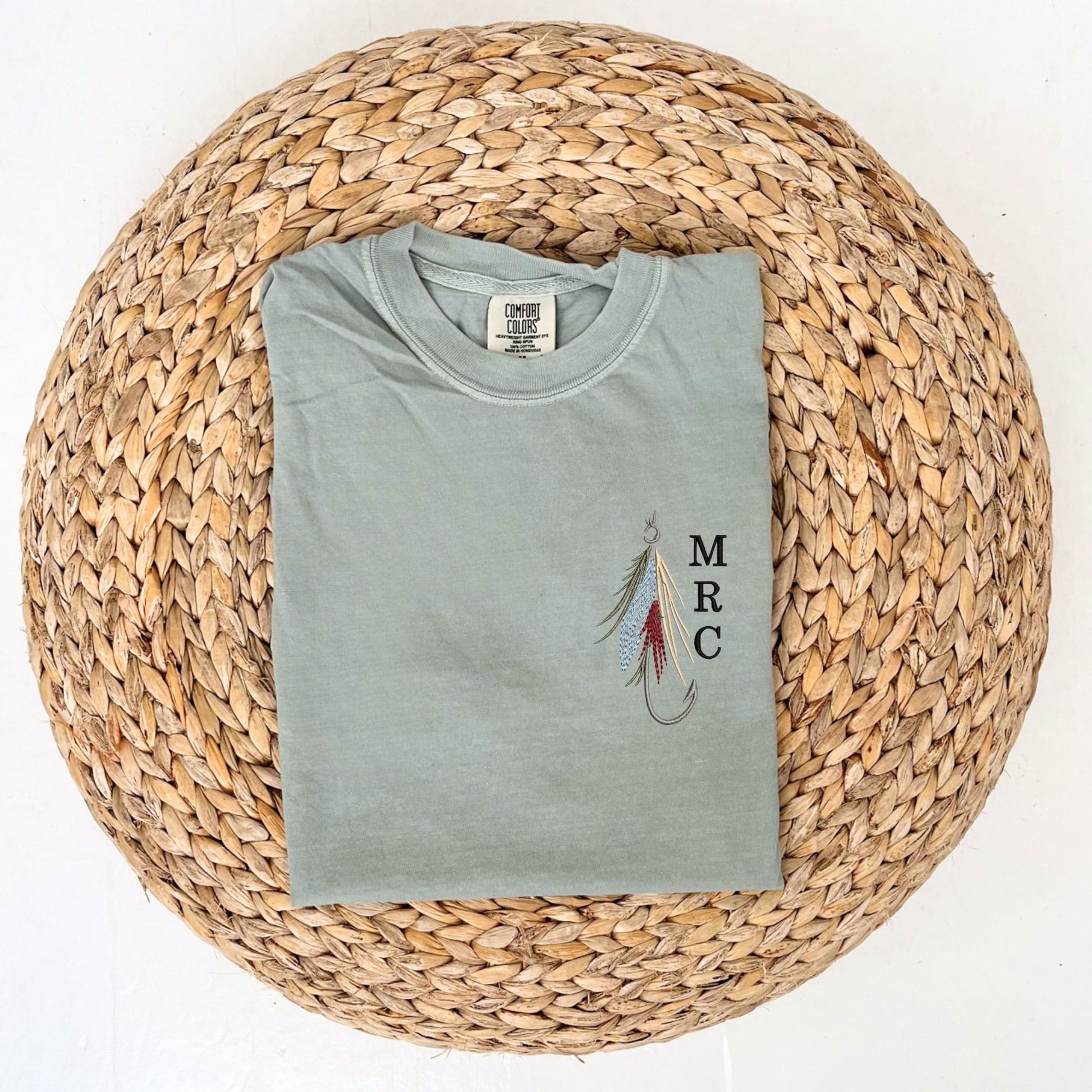 Bay Comfort Colors tshirt with custom fly fishing hook embroidered design featuring a mini initial monogram vertically next to it on the left chest 