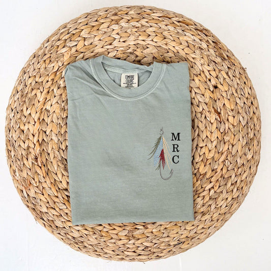 Bay Comfort Colors tshirt with custom fly fishing hook embroidered design featuring a mini initial monogram vertically next to it on the left chest 