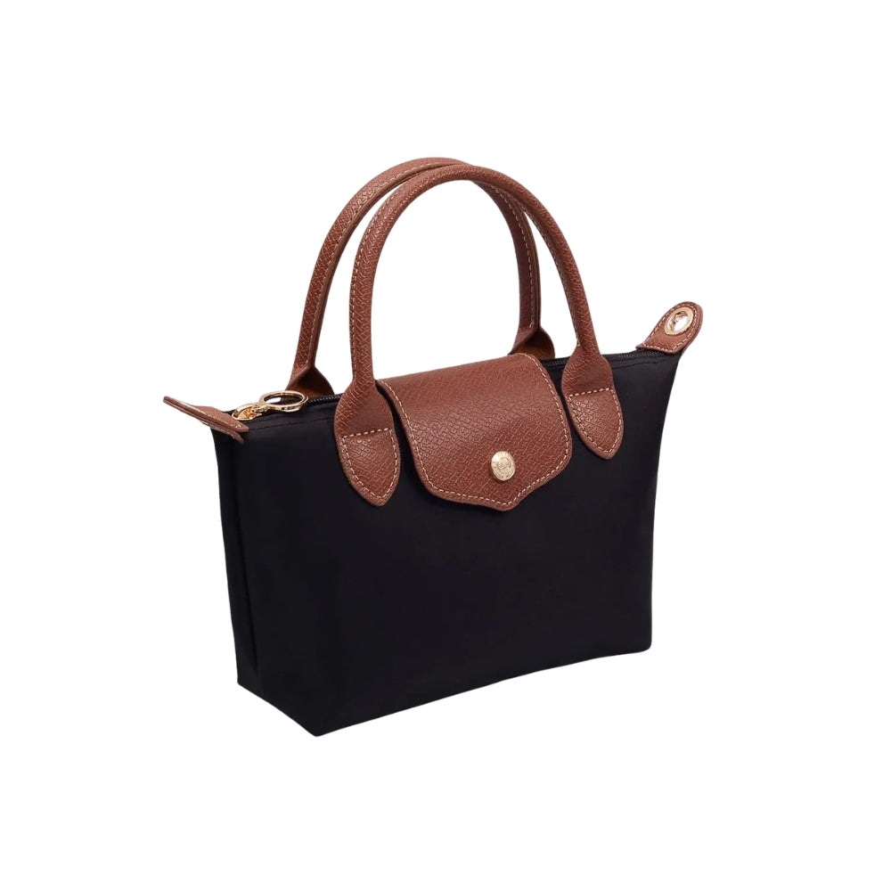 A black nylon tote bag with brown leather handles, trim, and flap closure, featuring a gold-tone snap button and zipper.