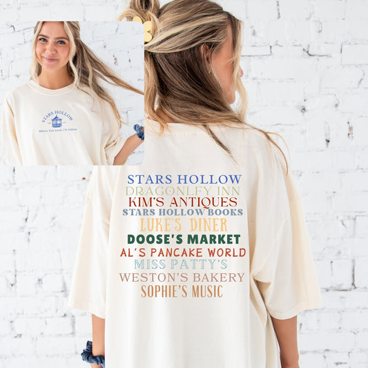 girl wearing an oversized comfort colors ivory t-shirt with a stars hollow gazebo print on the front and a list of iconic stars hollow locations on the back