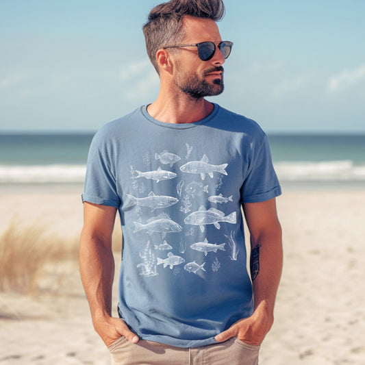 man standing on the beach wearing a blue jean comfort colors tee with a custom vintage sketched fish printed design on the full chest in white ink