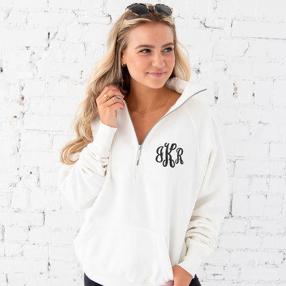 young woman wearing a sweet cream pullover boxy quarter zip with custom monogram embroidery