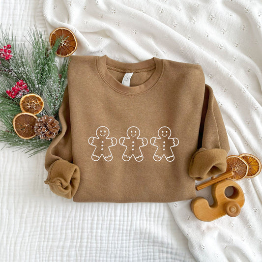 christmas styled flat lay photo of coyote brown toddler crewneck sweatshirt with 3 outlined gingerbread men embroidered in white thread