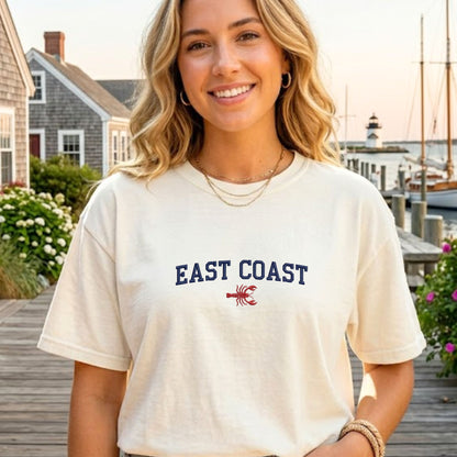 Woman wearing a 'East Coast' t-shirt with a lobster graphic on a dock background