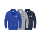 Three quarter-zip sweatshirts displayed side by side on a white background, in royal blue, heather gray, and navy blue. Each sweatshirt features a white embroidered logo on the left chest reading 'VILLA MADONNA MONTESSORI' with a small house icon.
