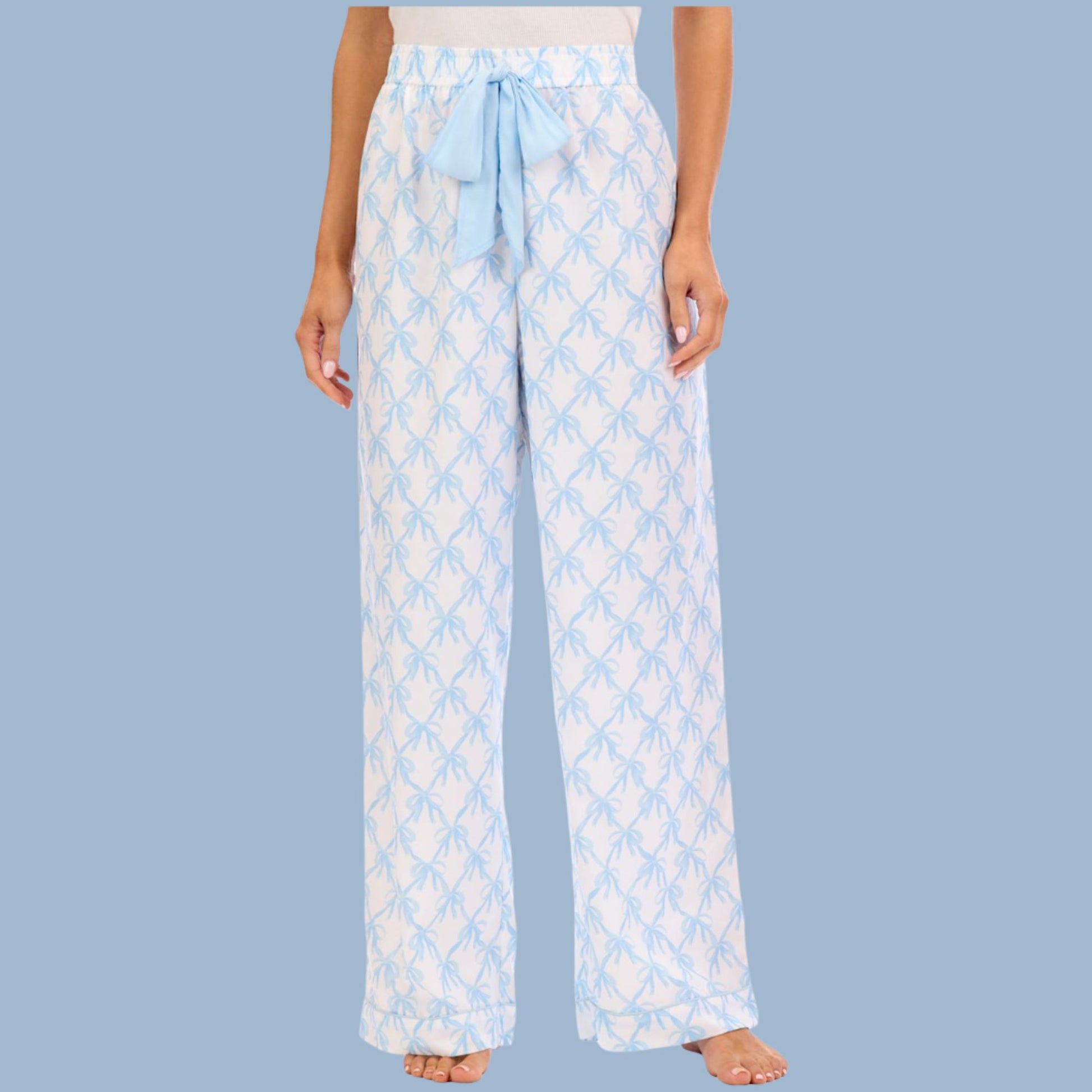 Light blue patterned pajama pants worn by a person on a light blue background