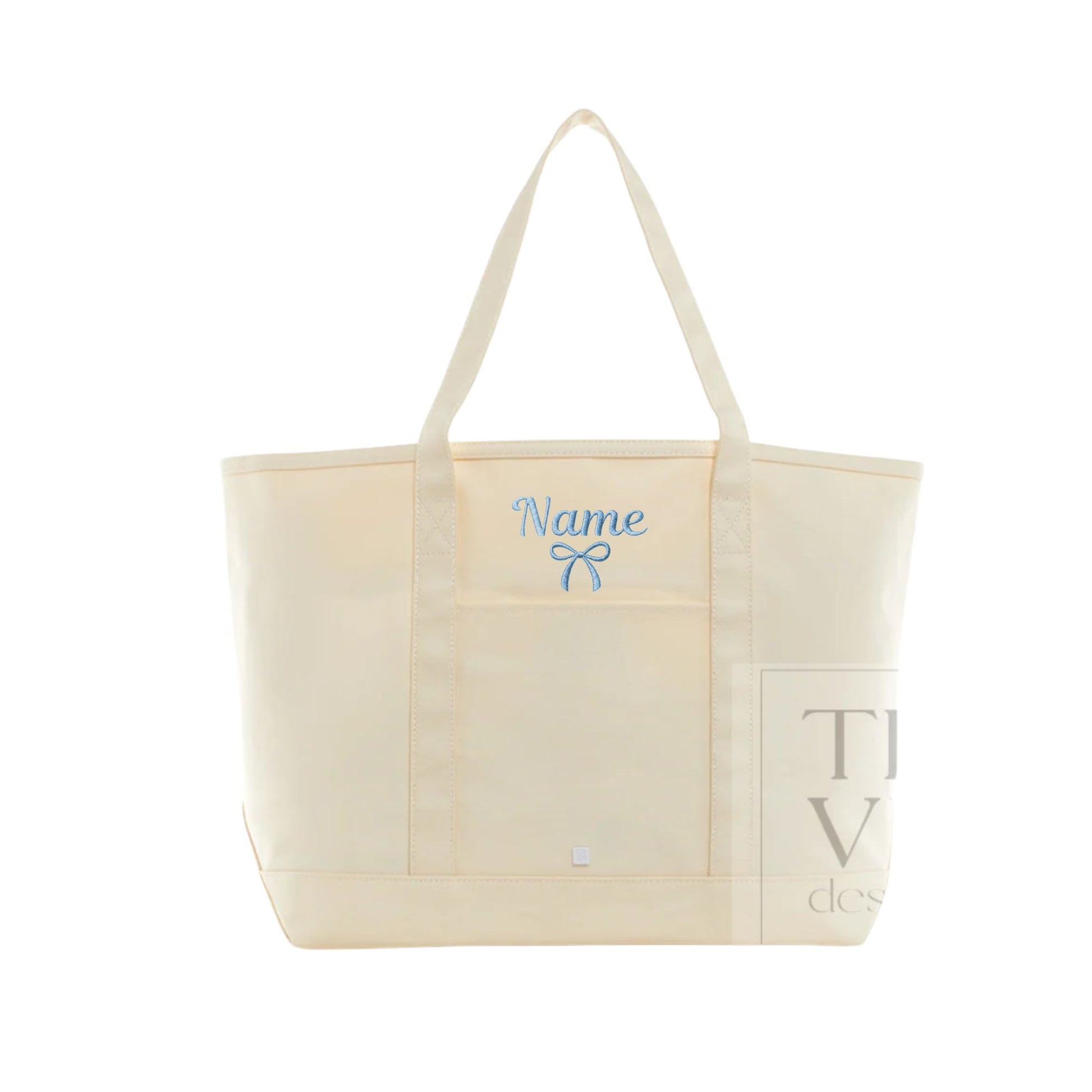 An off-white canvas tote bag with cream-colored handles, featuring a light blue embroidered bow and the word 'Name' on the front pocket, indicating personalization.